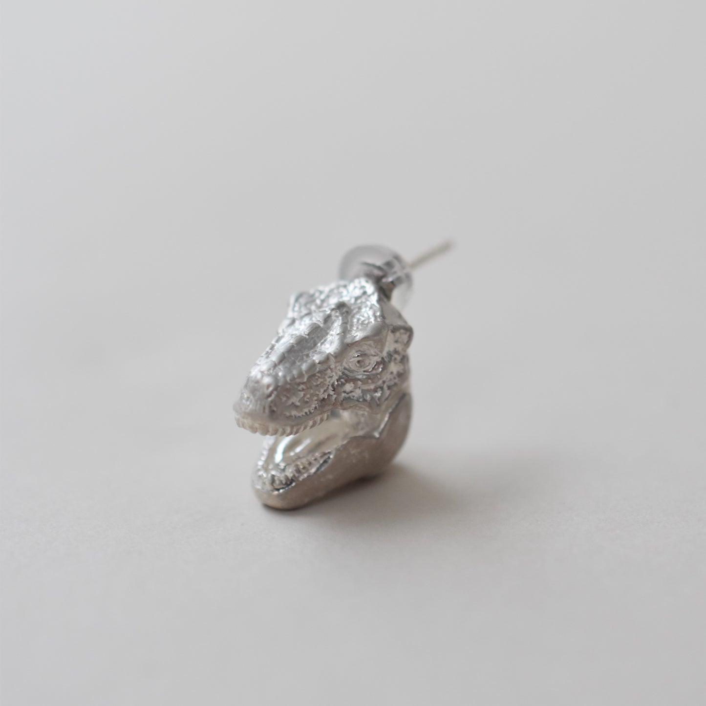 pierced earring tyrannosaurs face